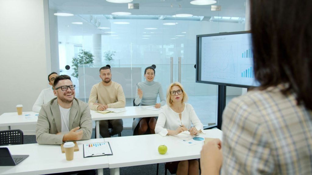 ADULTS sitting on chairs inside presentation room